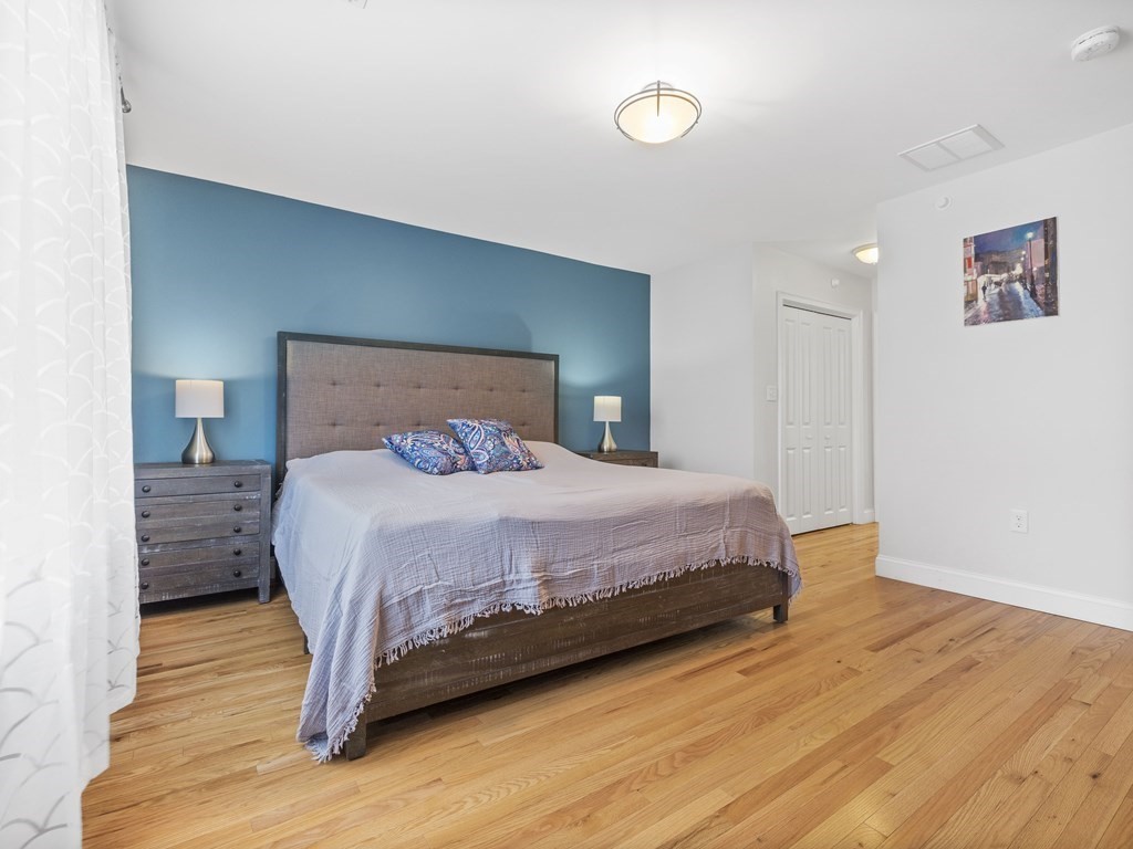 38 Webster Street, Unit 1 Needham, MA 02494 - Photo 13 of 35 a bedroom with a bed and wooden floor