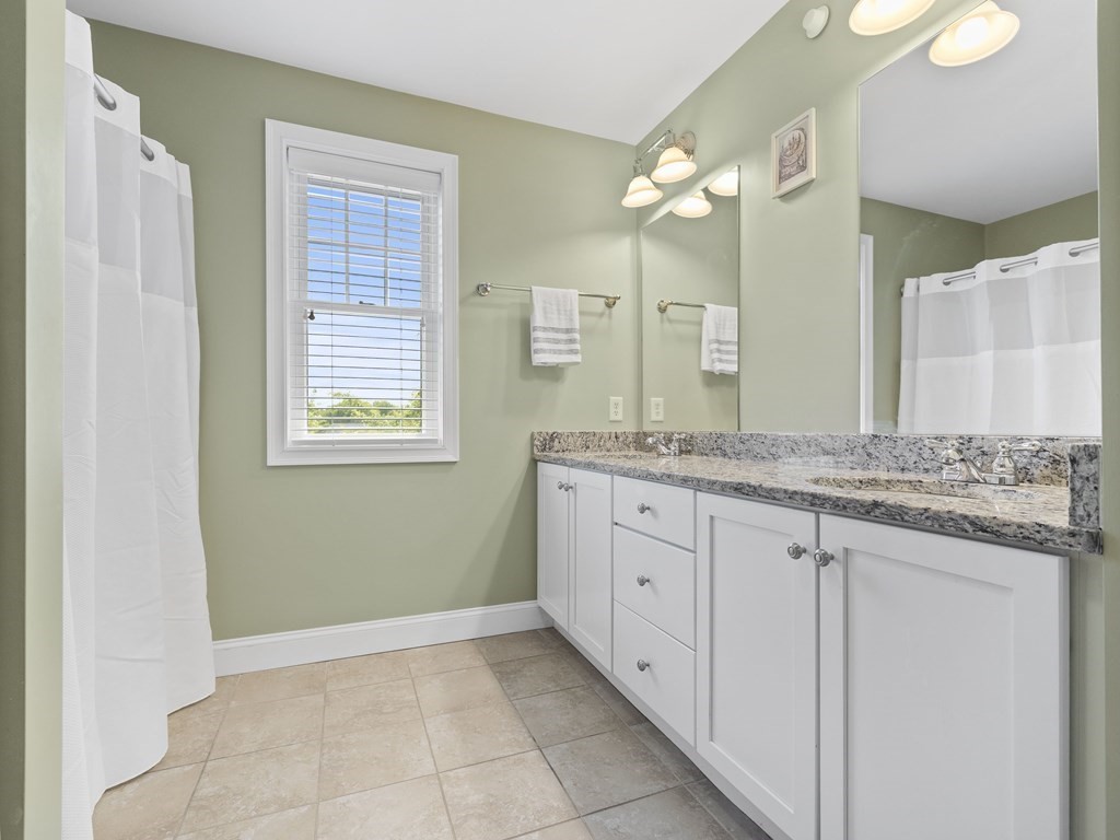 38 Webster Street, Unit 1 Needham, MA 02494 - Photo 14 of 35 a bathroom with a granite countertop sink a mirror and a