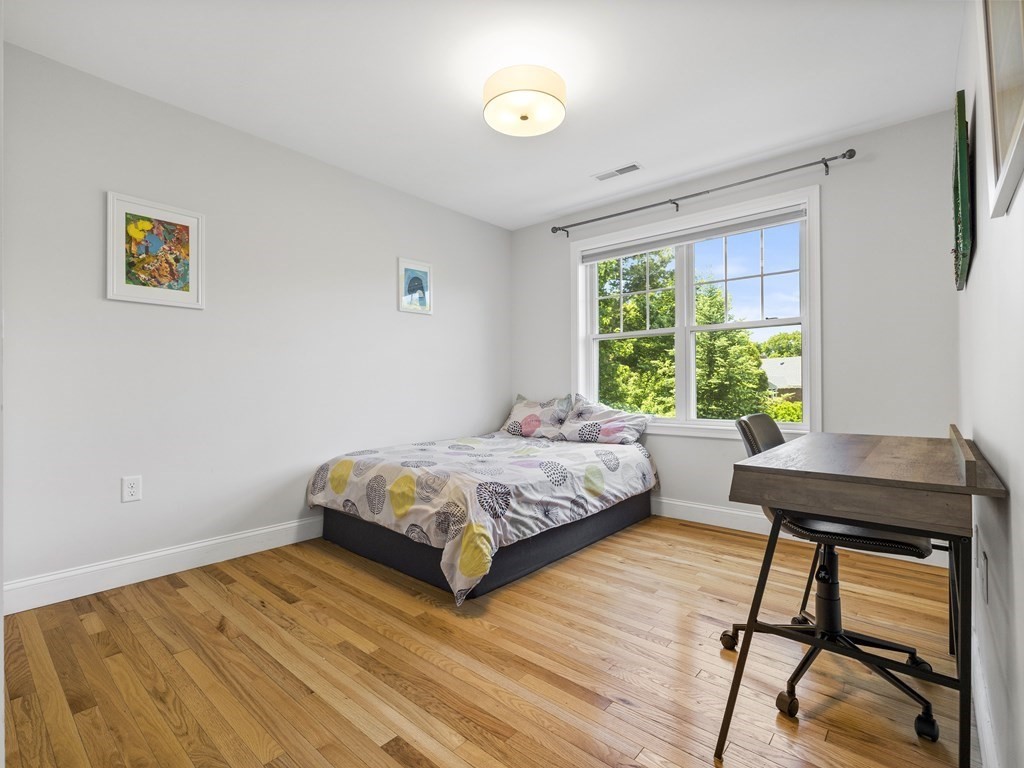 38 Webster Street, Unit 1 Needham, MA 02494 - Photo 16 of 35 a bedroom with a bed and a table in it