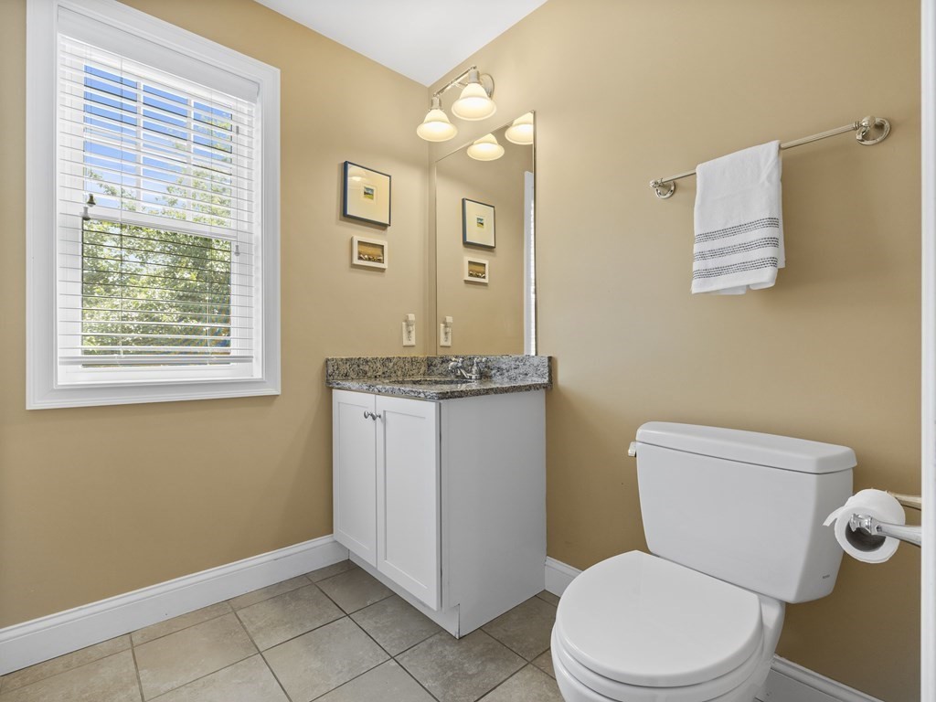38 Webster Street, Unit 1 Needham, MA 02494 - Photo 21 of 35 a white toilet sitting next to a bathroom sink vanity and granite