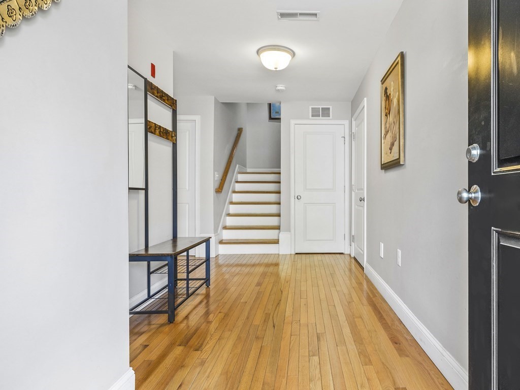 38 Webster Street, Unit 1 Needham, MA 02494 - Photo 22 of 35 a view of a hallway with wooden floor and staircase