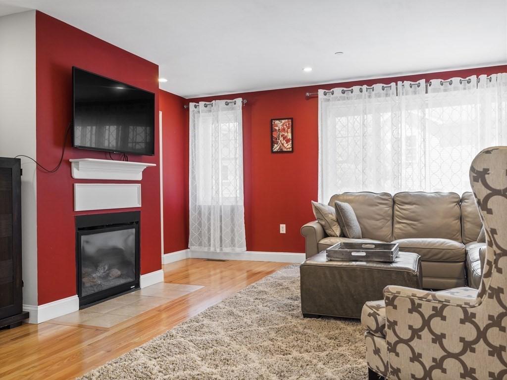 38 Webster Street, Unit 1 Needham, MA 02494 - Photo 4 of 35 a living room with furniture a flat screen tv and a fireplace