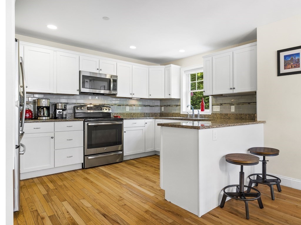 38 Webster Street, Unit 1 Needham, MA 02494 - Photo 6 of 35 a kitchen with stainless steel appliances a stove a sink a microwave and cabinets