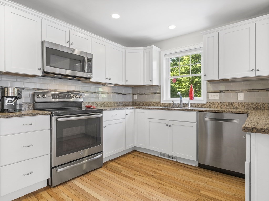 38 Webster Street, Unit 1 Needham, MA 02494 - Photo 7 of 35 a kitchen with stainless steel appliances granite countertop a sink a stove a microwave and cabinets