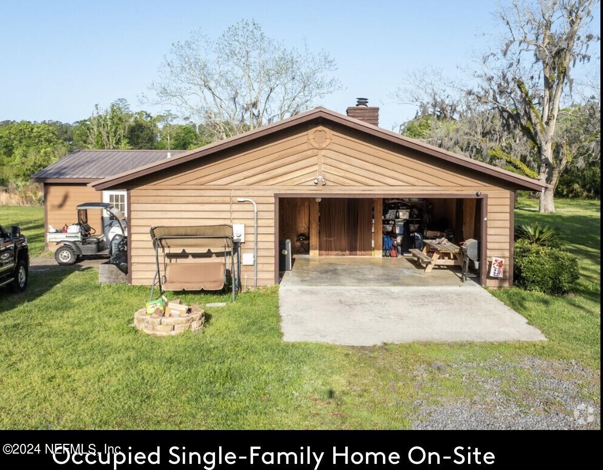 5464 George Hodges Road Macclenny, FL 32063 - Photo 15 of 23 a view of a patio with table and chairs under an umbrella