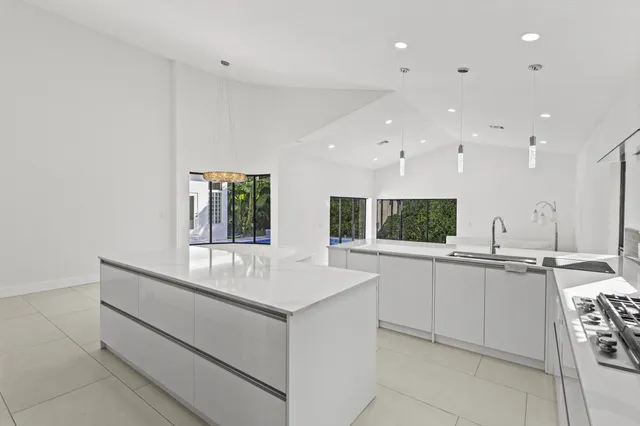 a large white kitchen with a large window