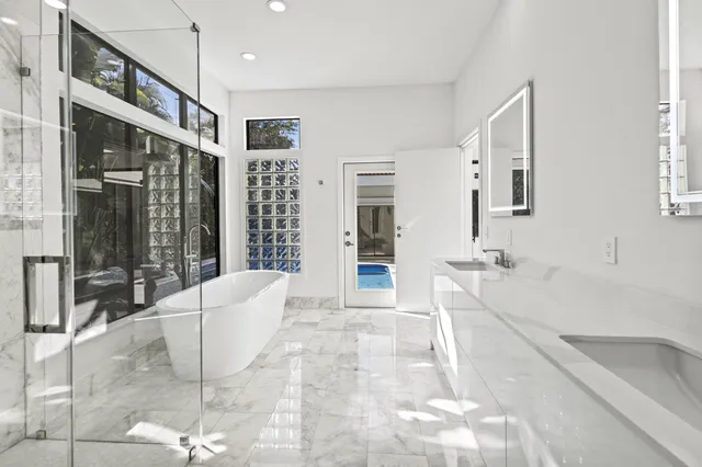 a spacious bathroom with a tub sink and mirror