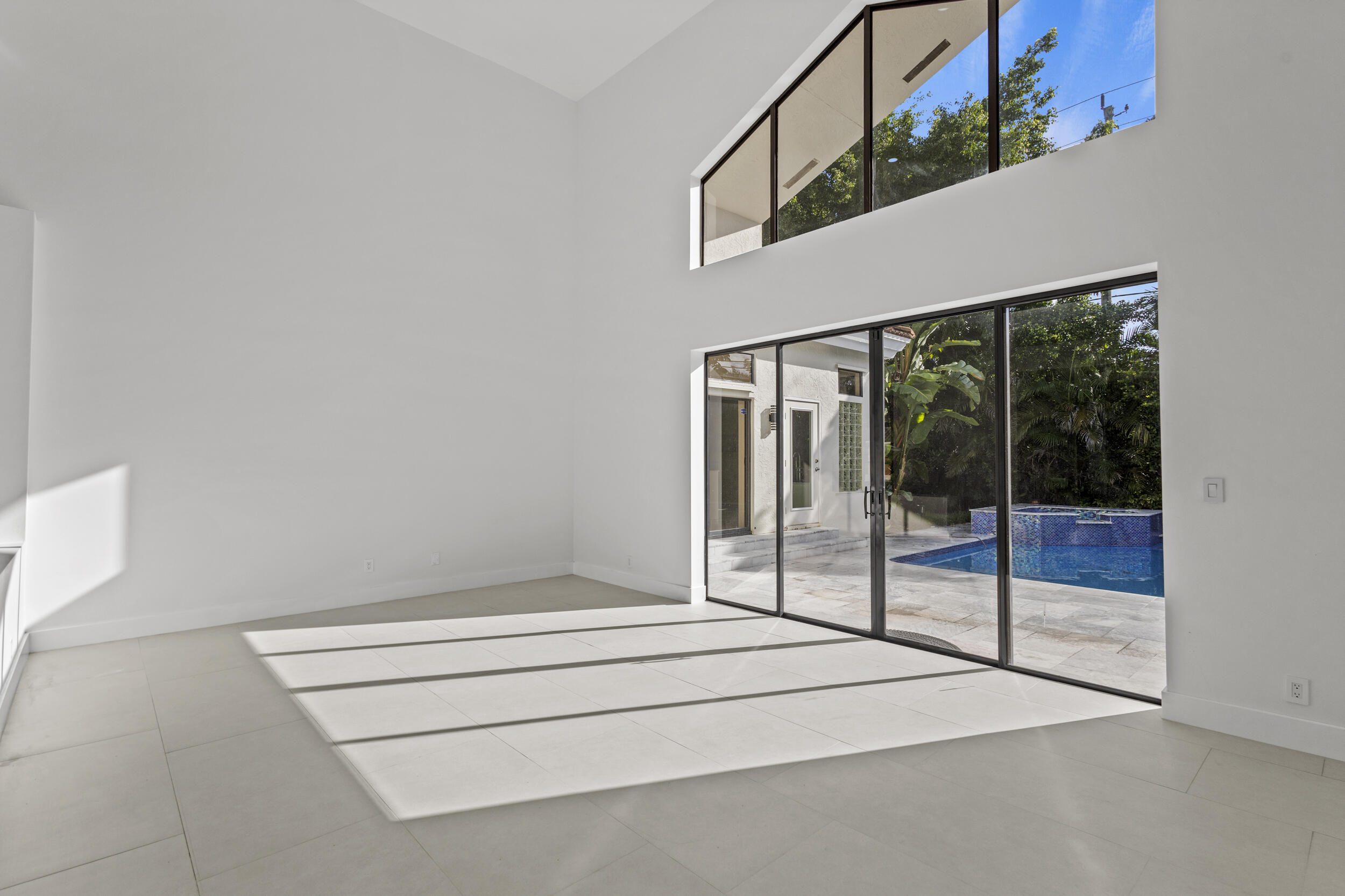 4798 Northwest 25th Way Boca Raton, FL 33434 - Photo 6 of 41 a spacious bedroom with a bed and glass door