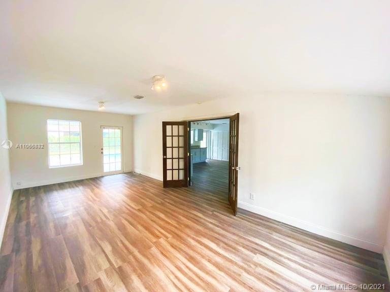 1275 Northeast 204th Terrace Miami, FL 33179 - Photo 20 of 49 a view of an empty room with wooden floor and windows