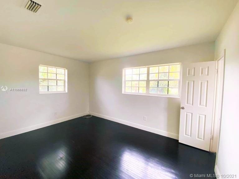 1275 Northeast 204th Terrace Miami, FL 33179 - Photo 23 of 49 an empty room with wooden floor and windows