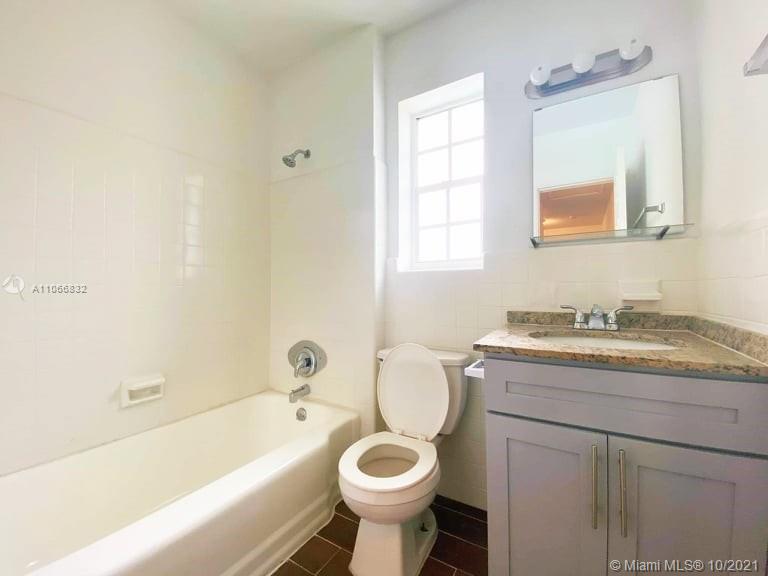 1275 Northeast 204th Terrace Miami, FL 33179 - Photo 24 of 49 a bathroom with a granite countertop toilet sink and mirror