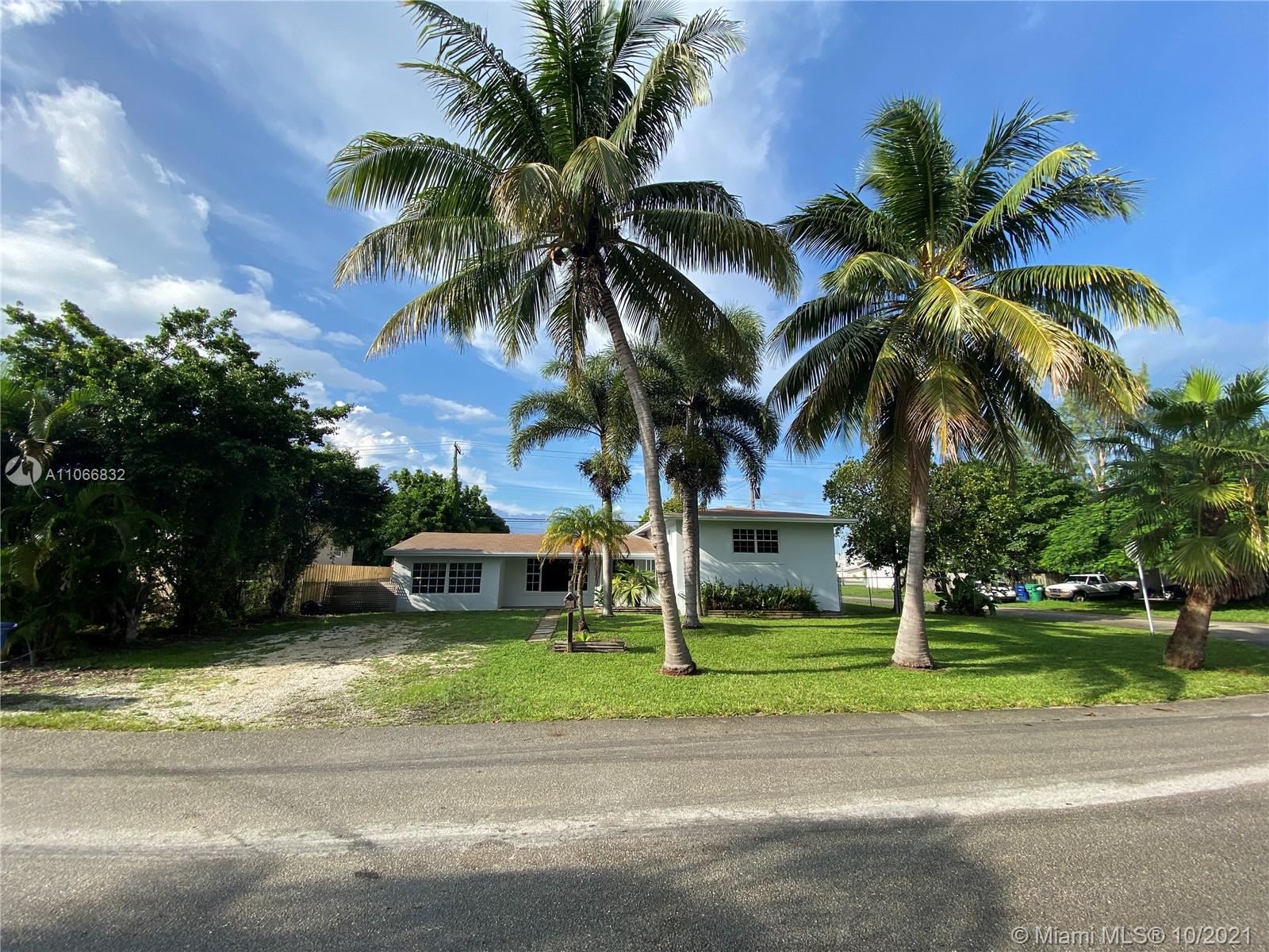 1275 Northeast 204th Terrace Miami, FL 33179 - Photo 34 of 49 a front view of a house with a garden and trees