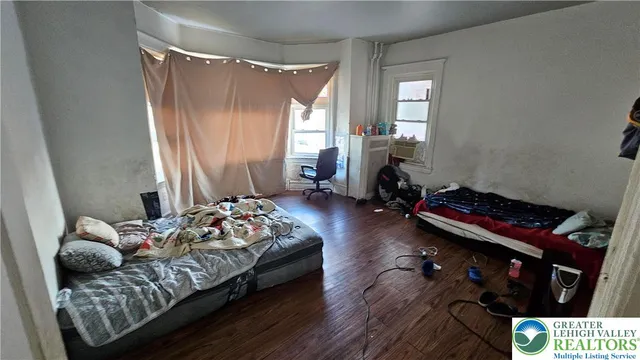 a view of a bedroom with wooden floor