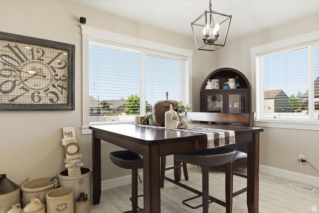 772 East 600 South Preston, ID 83263 - Photo 11 of 35 Dining area featuring two large windows with horizontal blinds, a dark wood-finish dining table, and light wood-finish flooring