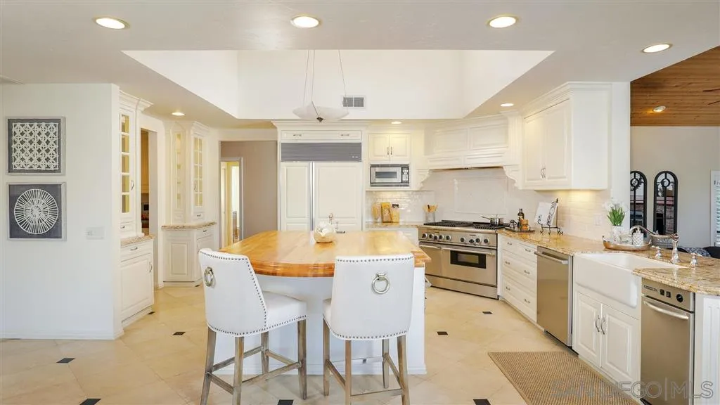 2723 Rich Lynn Ridge Road Escondido, CA 92025 - Photo 7 of 24 a large kitchen with a stove a sink a refrigerator and a dining table