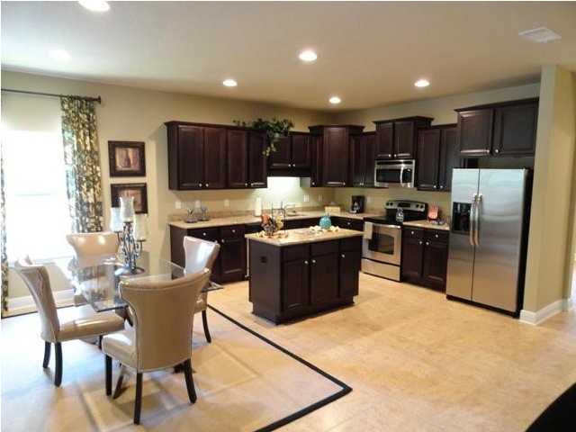 408 Pin Oak Loop Santa Rosa Beach, FL 32459 - Photo 1 of 14 a kitchen with stainless steel appliances kitchen island granite countertop a stove a sink a refrigerator a dining table and chairs