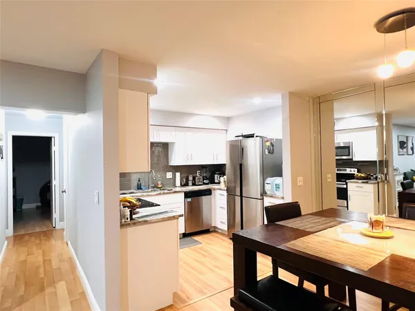 a kitchen with a refrigerator and a stove top oven