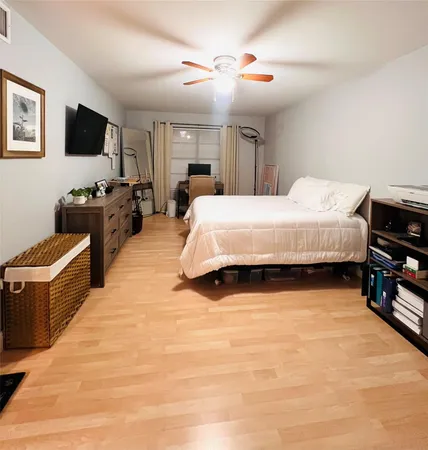 a spacious bedroom with a bed and a flat screen tv