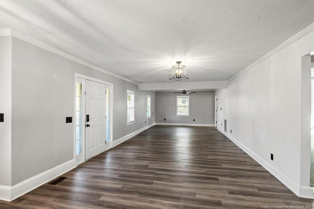 912 Main Street Raeford, NC 28376 - Photo 4 of 36 an empty room with wooden floor chandelier and windows