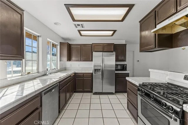 a kitchen with stainless steel appliances granite countertop a stove a refrigerator and a cabinets