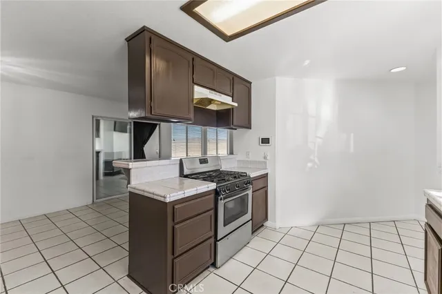 a kitchen with stainless steel appliances granite countertop a sink stove and cabinets