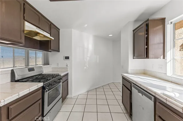a kitchen with stainless steel appliances granite countertop a sink and a stove