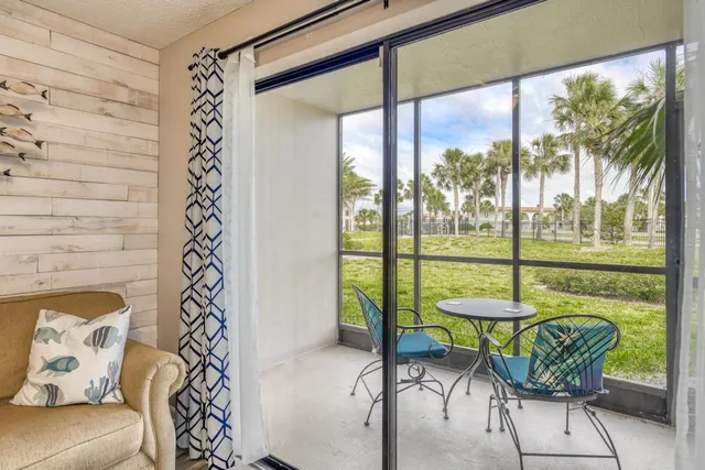 a living room with furniture and a floor to ceiling window