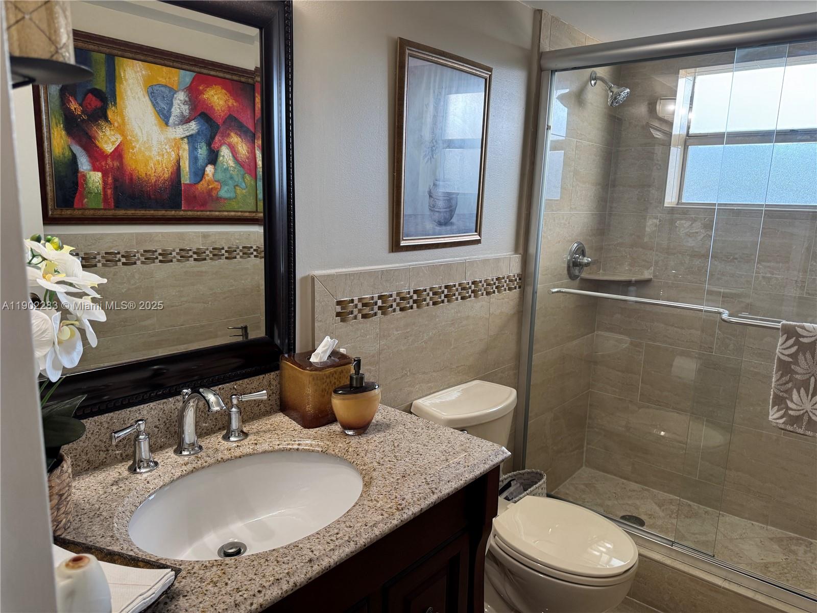8330 Sands Point Boulevard, Unit N208 Tamarac, FL 33321 - Photo 12 of 35 a bathroom with a granite countertop sink mirror vanity and toilet