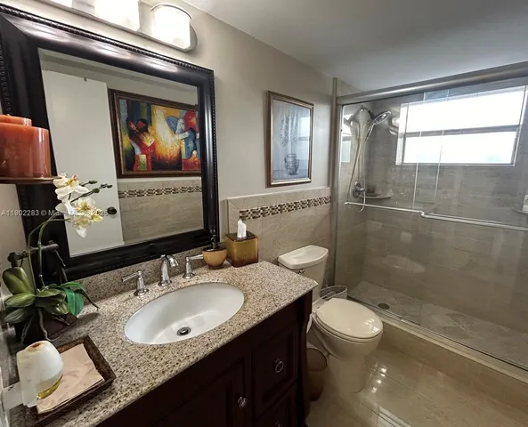 a bathroom with a sink vanity granite and toilet