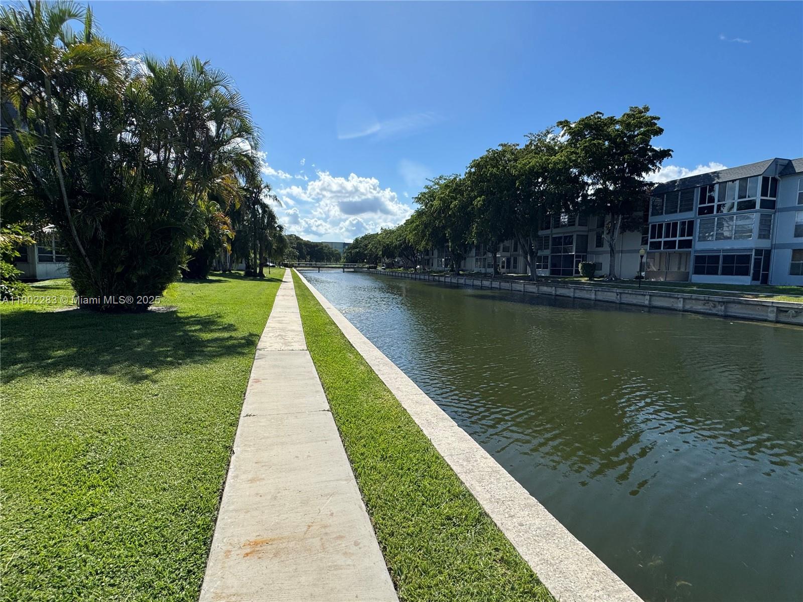 8330 Sands Point Boulevard, Unit N208 Tamarac, FL 33321 - Photo 32 of 35 a view of a lake with a garden