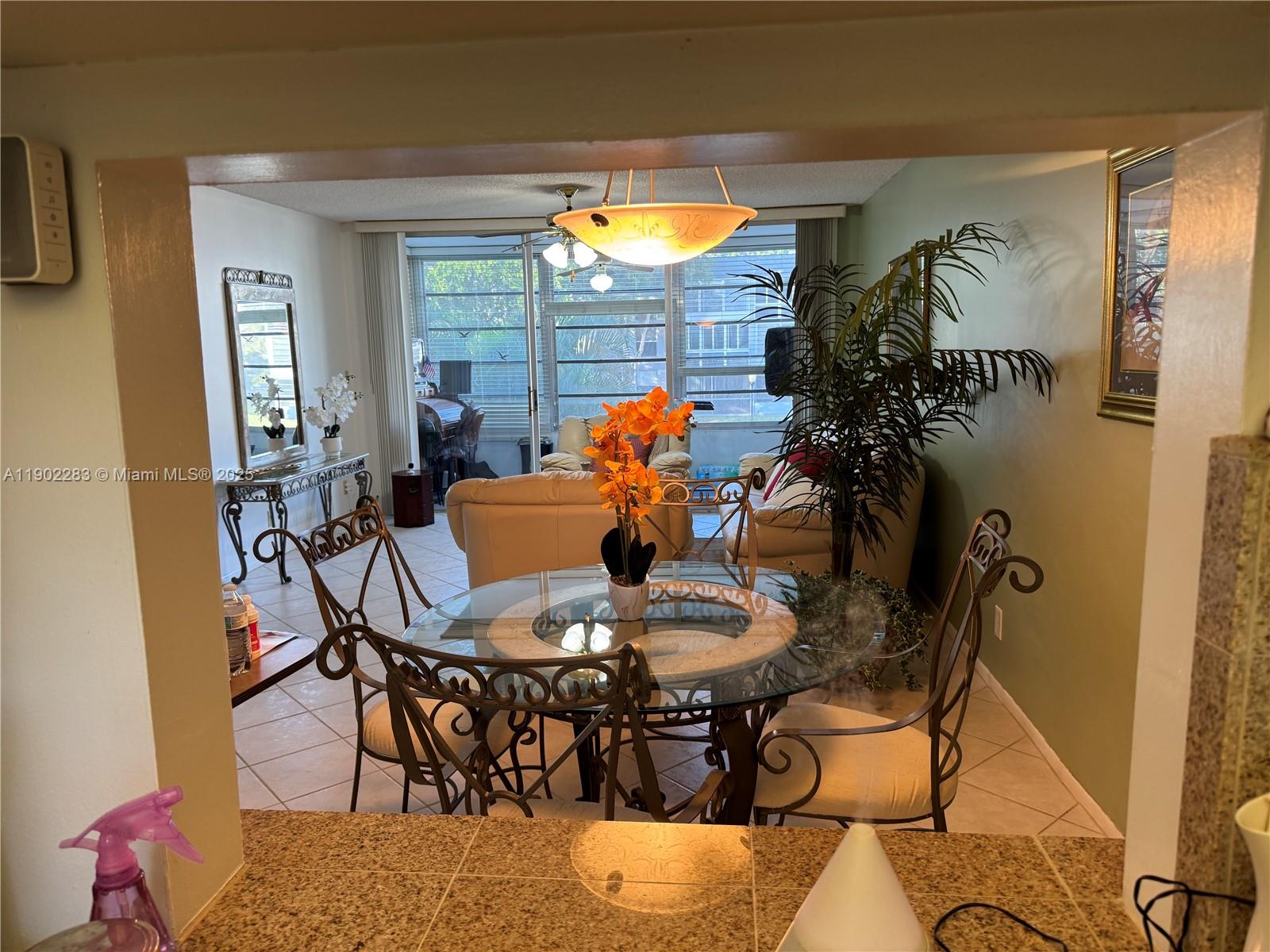 8330 Sands Point Boulevard, Unit N208 Tamarac, FL 33321 - Photo 5 of 35 a dining room with furniture a rug and a window