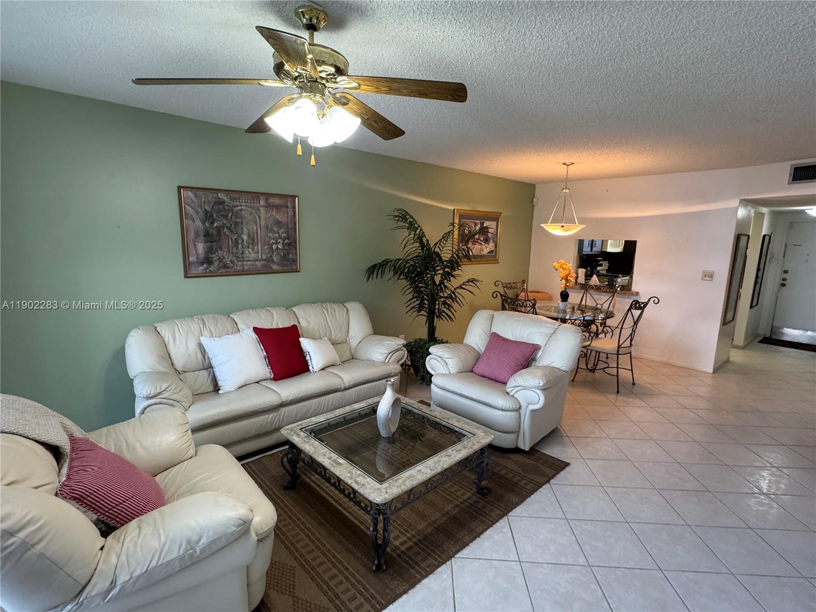 8330 Sands Point Boulevard, Unit N208 Tamarac, FL 33321 - Photo 7 of 35 a living room with furniture and a chandelier
