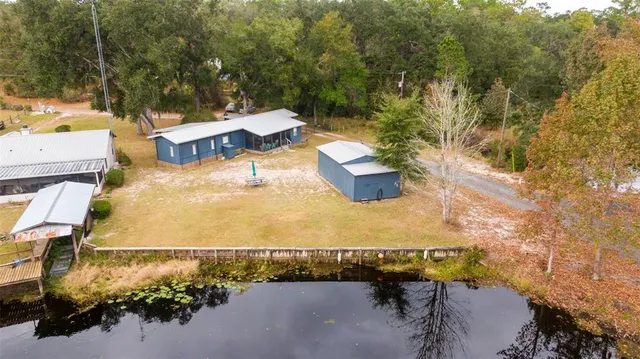 an aerial view of a house with a yard and lake view