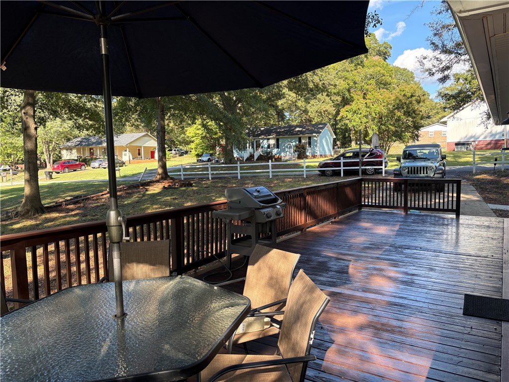 306 Hemlock Avenue Anderson, SC 29625 - Photo 20 of 25 An elevated wooden deck overlooks a grassy neighborhood landscape bordered by mature trees.
