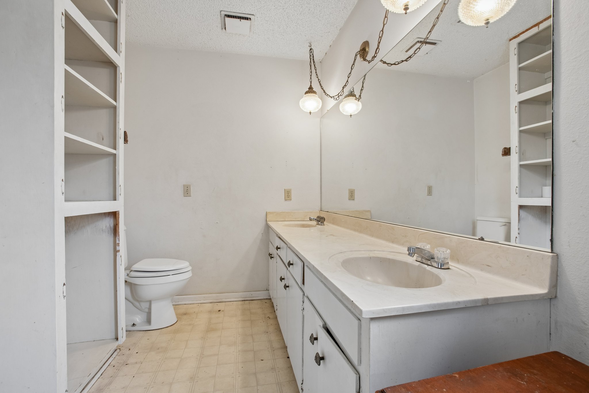406 Monkey Road Elgin, TX 78621 - Photo 17 of 39 Bathroom featuring a double vanity with integrated sinks, a full-width wall mirror, and dual built-in shelving units