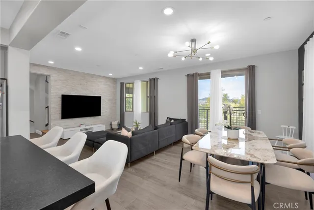 a kitchen with stainless steel appliances granite countertop a stove a sink a microwave a refrigerator and white cabinets