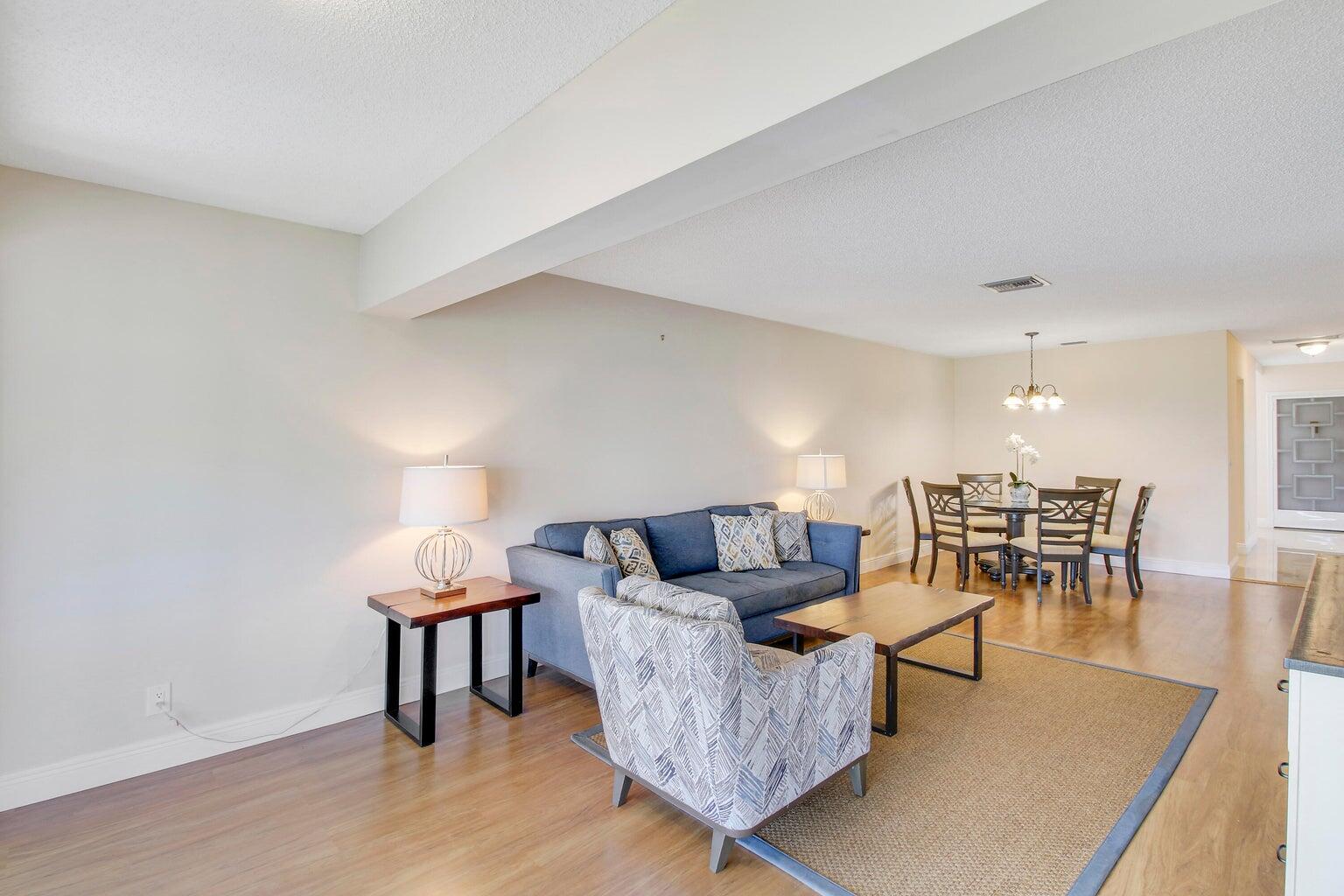 2730 Southwest 13th Street, Unit 203 Delray Beach, FL 33445 - Photo 2 of 23 a living room with furniture and a table