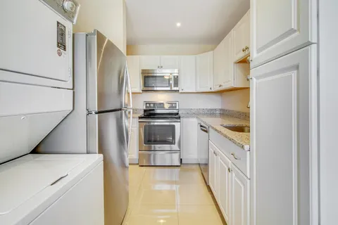 a kitchen with white cabinets and stainless steel appliances