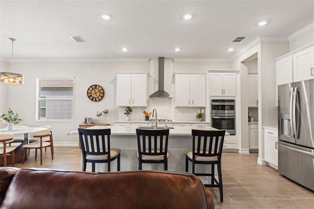 4661 Southern Valley Loop Brooksville, FL 34601 - Photo 11 of 62 a kitchen with stainless steel appliances kitchen island granite countertop a dining table chairs and a refrigerator