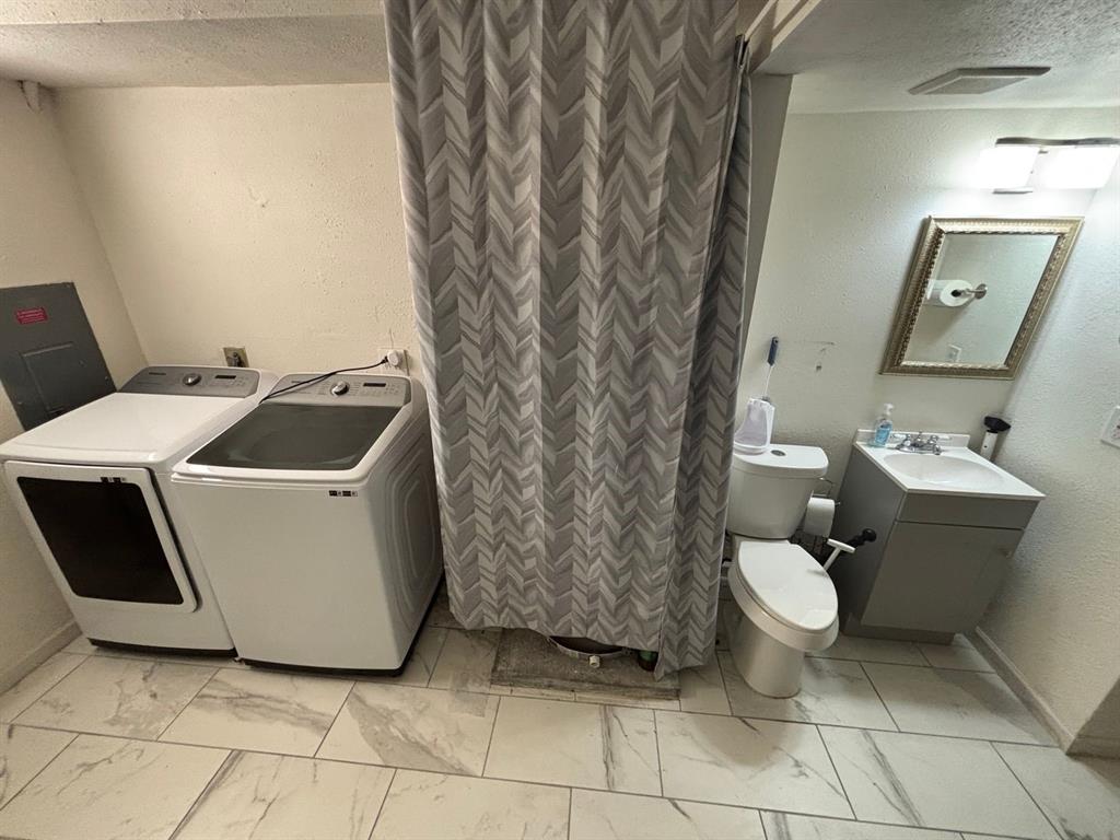 2113 Via Del Norte Carrollton, TX 75006 - Photo 11 of 24 a white toilet sitting next to a bathroom sink