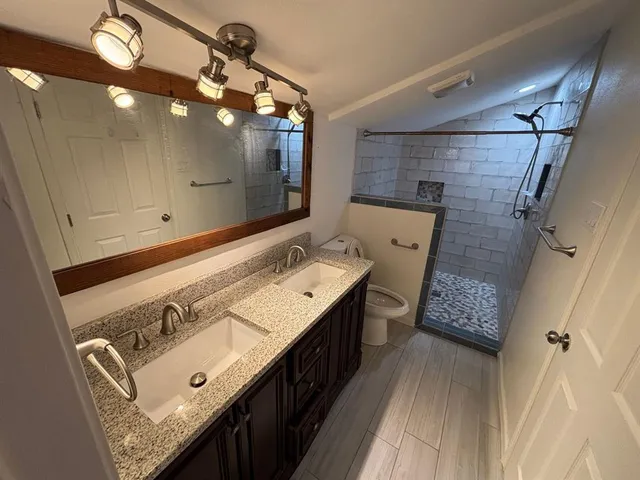 a bathroom with a double vanity sink and mirror