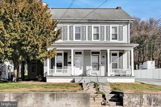 a front view of a house with swimming pool and porch