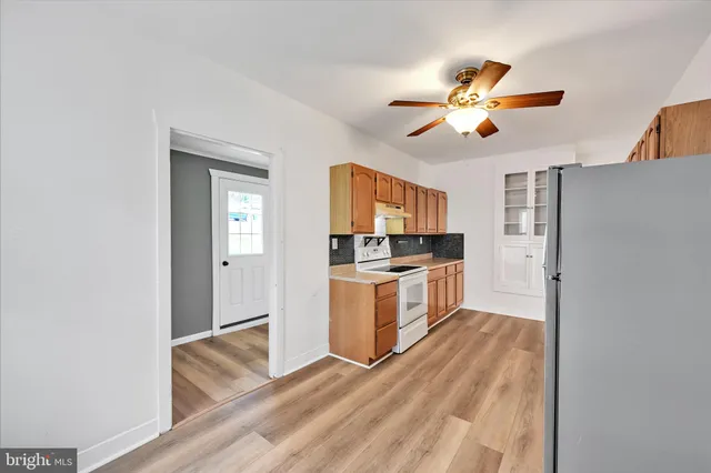 a kitchen with a refrigerator and a stove top oven