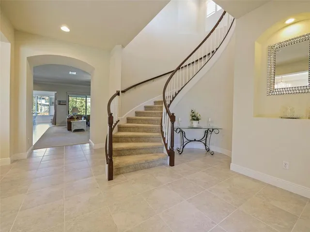 a spacious bedroom with a bed and a chandelier