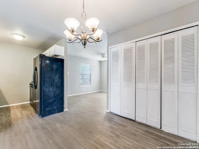 a large kitchen with cabinets wooden floor and stainless steel appliances
