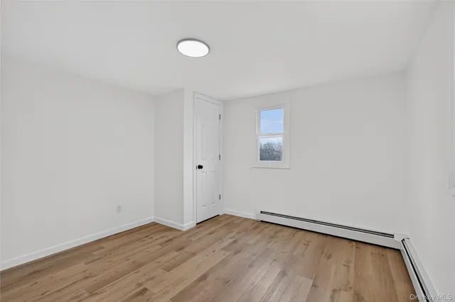 a view of a room with wooden floor and white walls