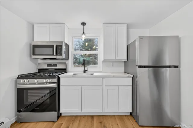 a kitchen with a stove a refrigerator and a microwave