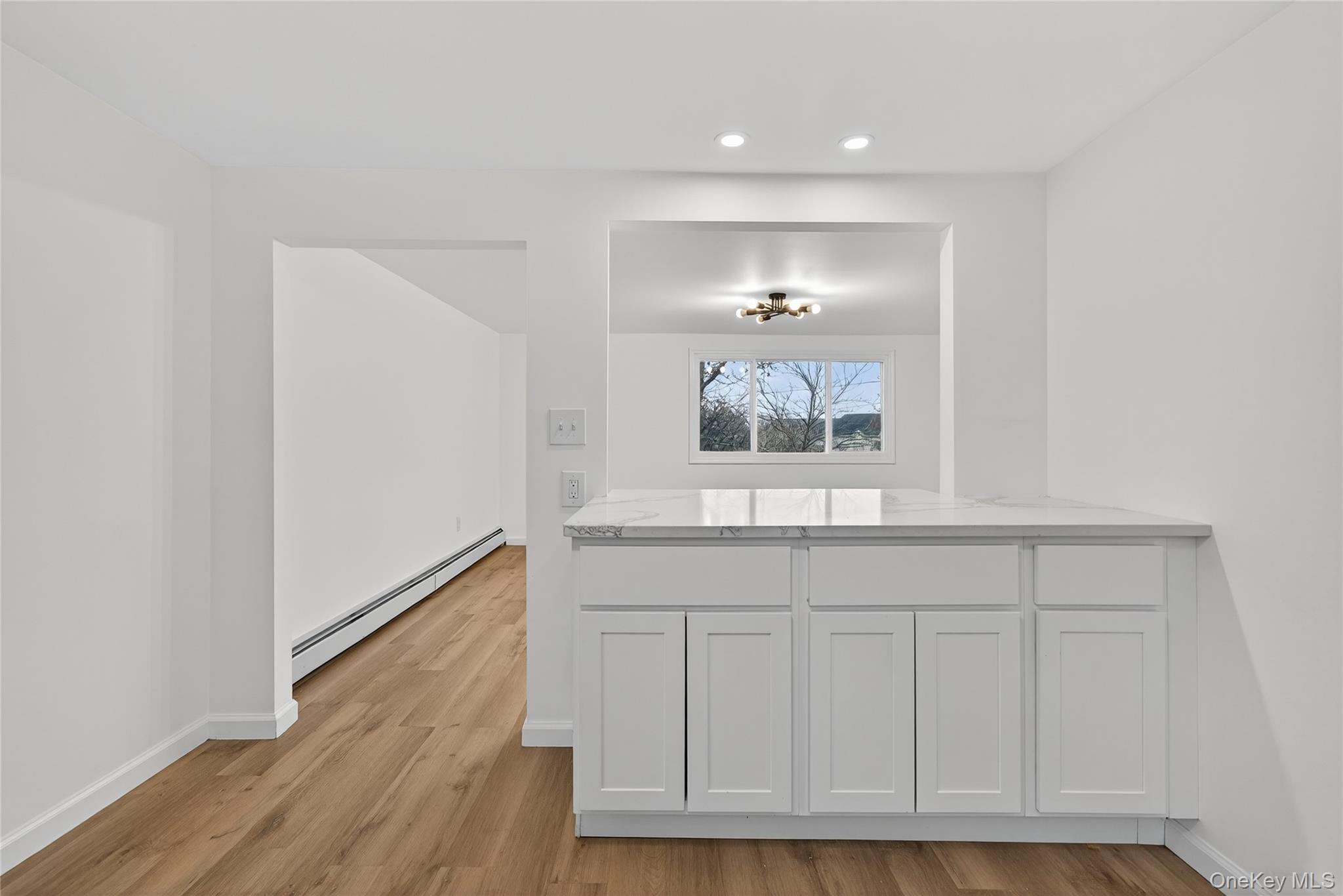 193 Schutt Road Middletown, NY 10940 - Photo 8 of 20 a hallway with white cabinets and wooden floor