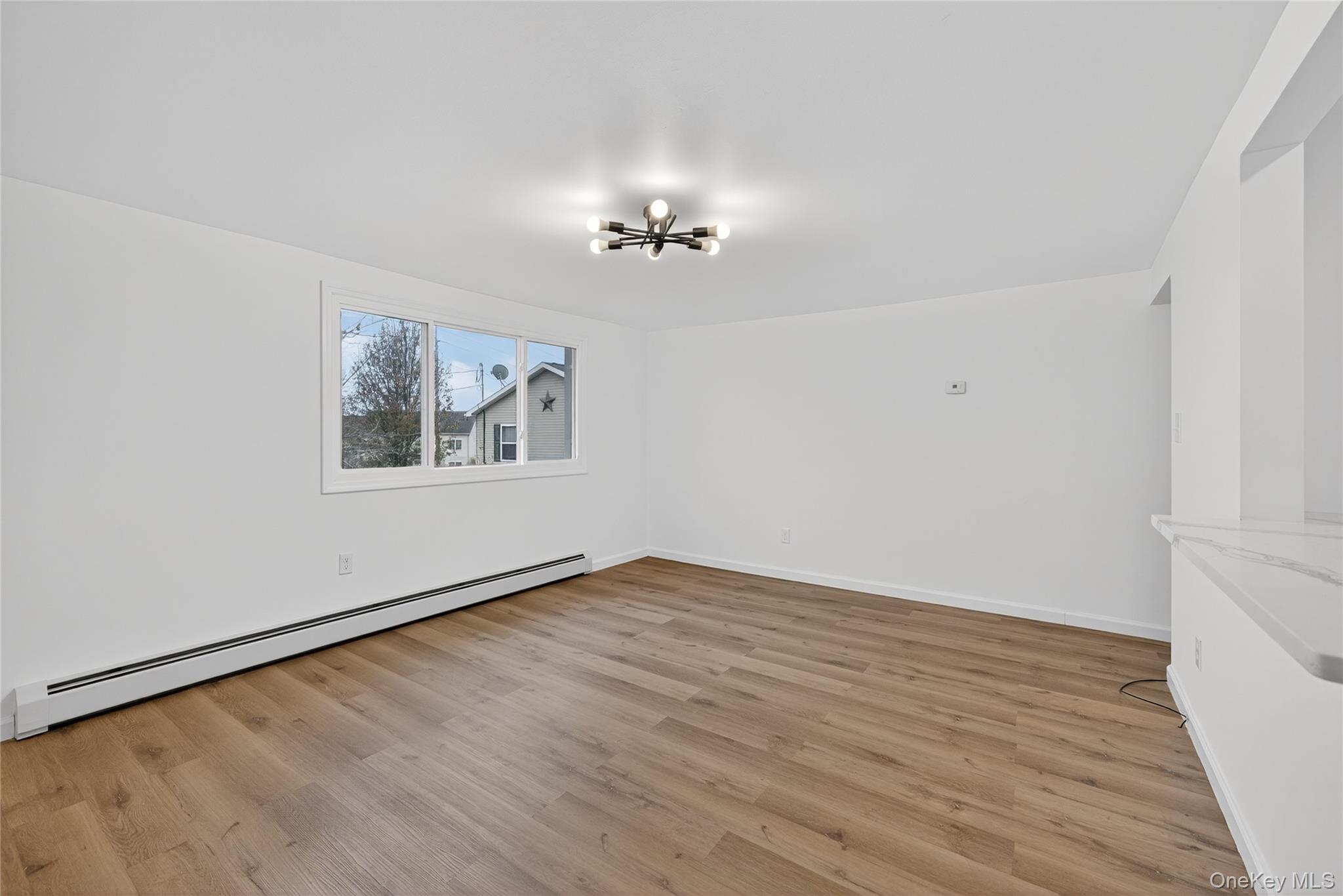 193 Schutt Road Middletown, NY 10940 - Photo 10 of 20 an empty room with wooden floor chandelier fan and windows