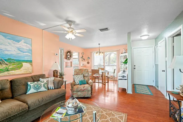 a living room with furniture wooden floor and a large window